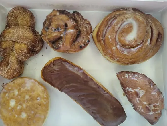 A half dozen assorted specialty rolls and filled donuts