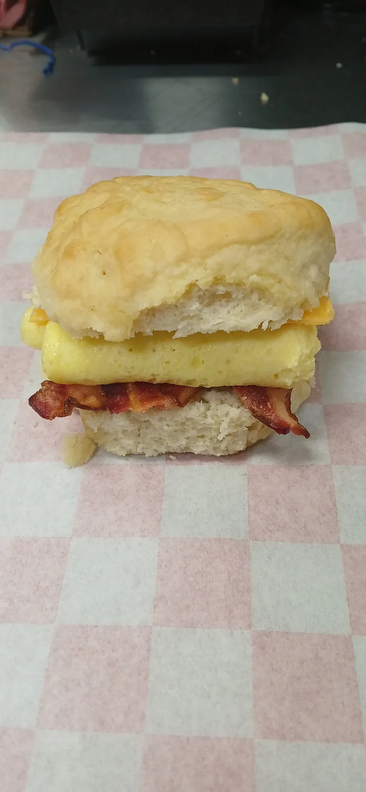 A biscuit breakfast sandwich with bacon and egg