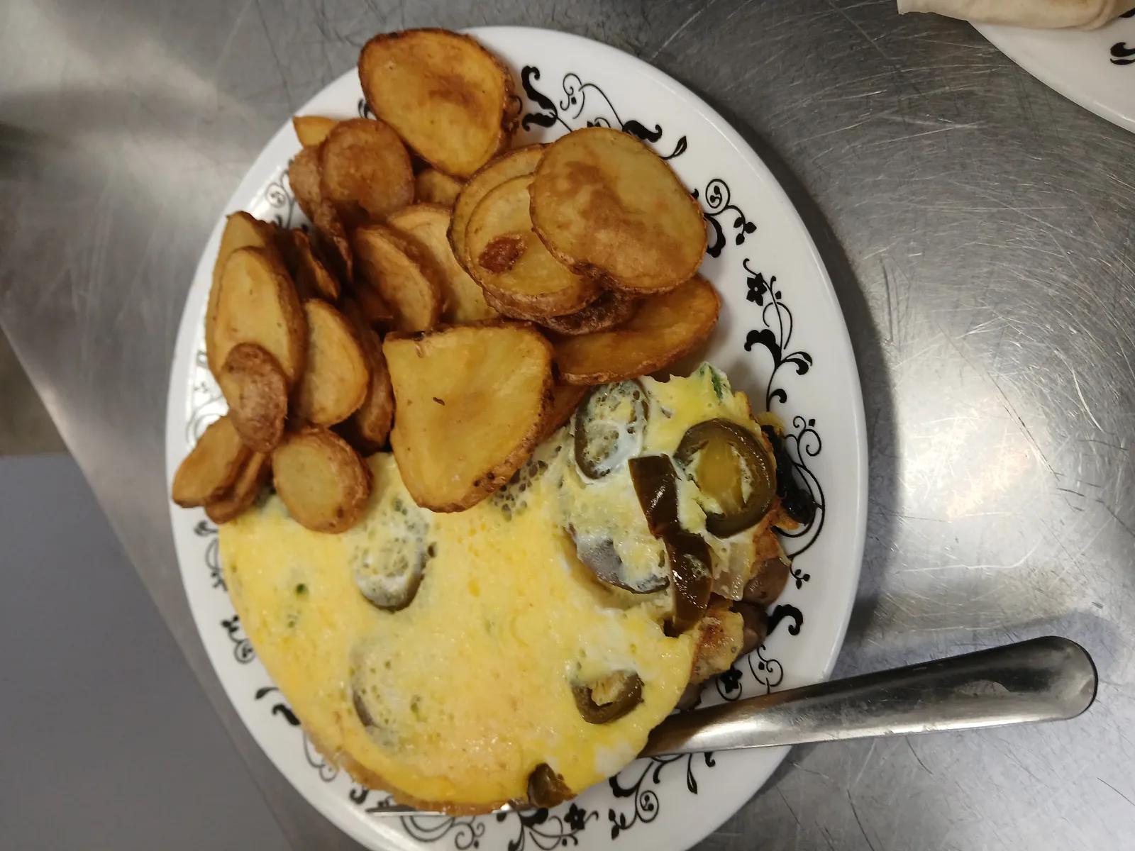 An omelet with jalapenos, served with deep-fried sliced potatoes