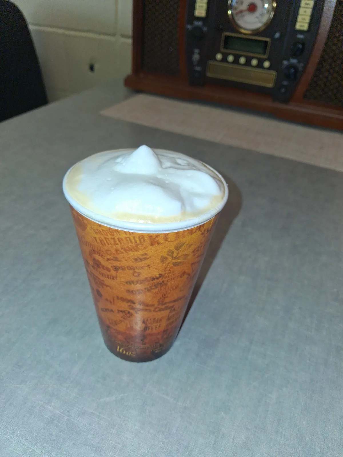 A 16 ounce latte with a thick cap of steamed milk foam